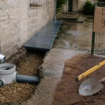 Drainage eau de pluie gouttière : descente zinc vers regard PVC et tuyau enterré